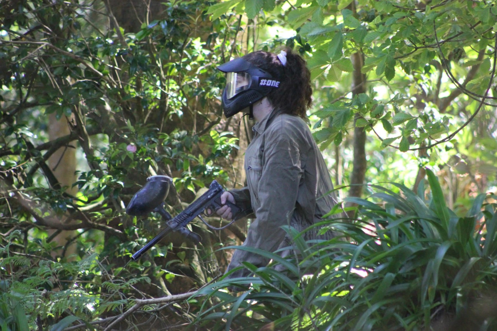 Jogadora de paintball com máscara de proteção numa floresta da Madeira