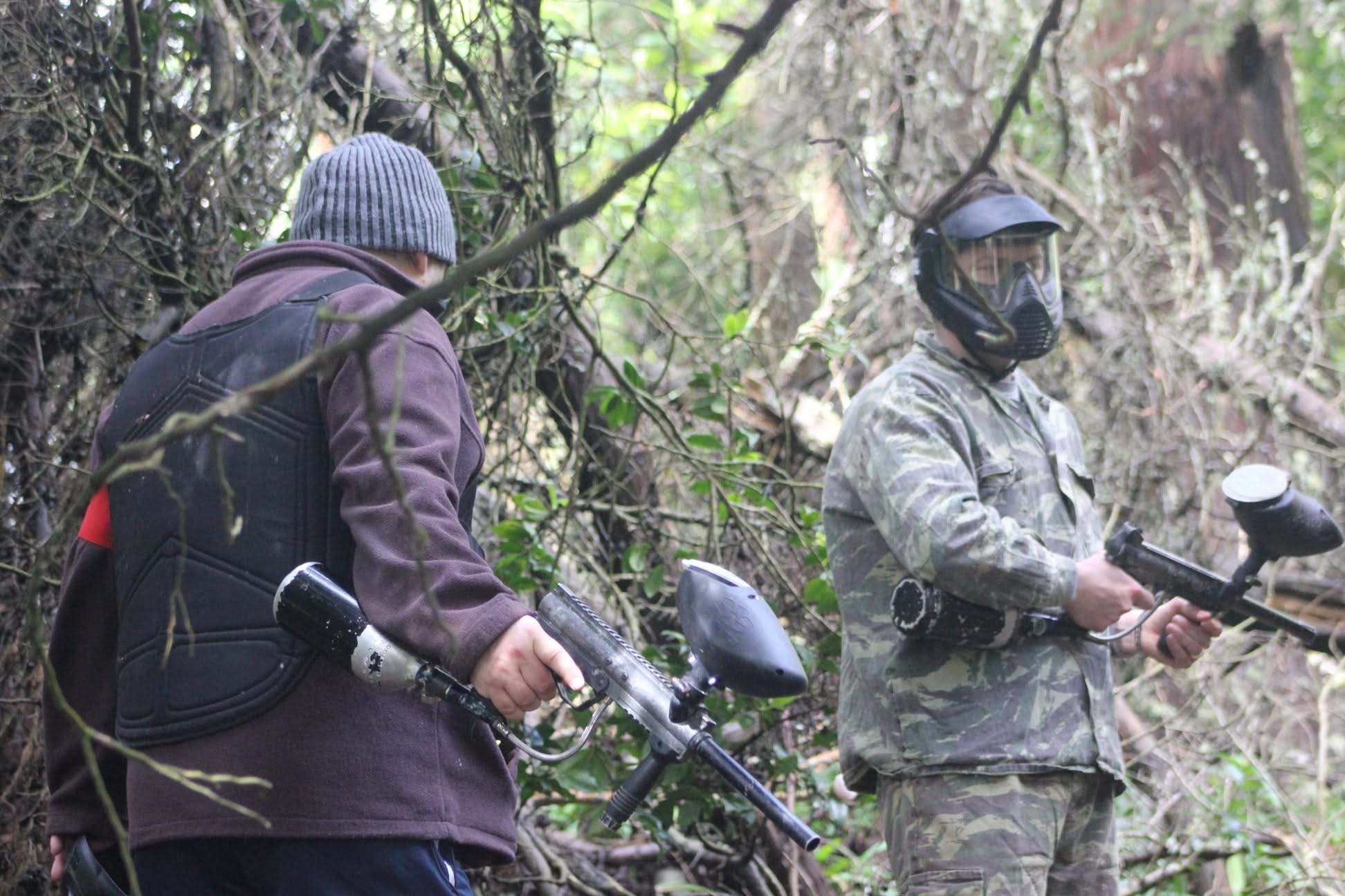 Dois jogadores de paintball a preparar os marcadores no campo